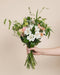 Eine Hand hält den Blumenstrauss Pfirsichgarten in der Grösse Classic mit 13 Stielen