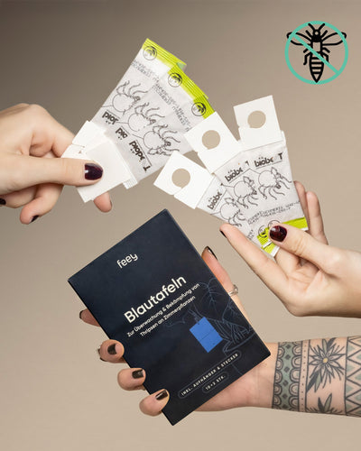 Eine tätowierte Person hält das Bekämpfungsset gegen Thripse in der Hand, während andere weiße und gelbe Papierstreifen mit Insektenbildern zeigen. In der rechten oberen Ecke ist ein Bienensymbol zu sehen.